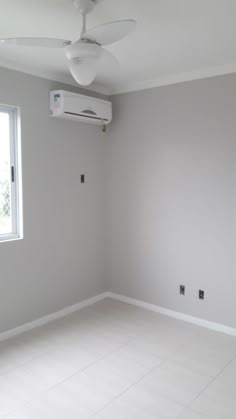 an empty room with a white ceiling fan and no one in the room around it