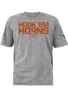 Show off your team pride in this Texas Longhorns Grey Hook Em Sign Short Sleeve T Shirt! This Texas Short Sleeve Tee features a center front and left sleeve screen print graphic. Make sure everyone knows you root for the Longhorns with this Grey Texas T Shirt. Hook Em Horns! Center front screen print "HOOK 'EM HORNS", Left sleeve screen print Longhorn graphic, Crew neck, Unisex, Fit: True to Size, 90% Cotton / 10% Polyester Athletic Heather Crew Neck Top With Team Logo, Athletic Heather Top With Team Name For Fans, Collegiate Athletic Heather Top With Graphic Print, Athletic Heather Fan Apparel Top With Team Logo, Athletic Heather Tops With Team Logo For Fans, Athletic Heather Tops With Logo Print For Fans, Athletic Heather Graphic Print Tops For Fan Gear, Athletic Heather Tops With Graphic Print For Fans, Sports Season Tops With Team Logo For Team Events