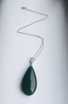 A gorgeous dark green jade pendant necklace. The big teardrop pendant comes with shiny diamond-like small teardrop stones and a 925 sterling silver necklace. Simple but elegant. Perfect as a gift for yourself or your loved ones. Highlights of this breath-taking teardrop round jade pendant are: ＊High-quality materials Made from quality jade and 925 sterling silver. Friendly to sensitive skins and ensure long-lasting color ＊Simple & Elegant Minimalistic style goes well with all sorts of occasi Elegant Emerald Teardrop Necklace, Green Drop Necklaces In Fine Jewelry Style, Elegant Green Pendant Drop Necklace, Elegant Green Teardrop Necklace, Elegant Drop Necklace With May Birthstone, Elegant May Birthstone Drop Necklace, Elegant Green Gemstone Drop Necklace, Green Teardrop Pendant Jewelry For Formal Occasions, Green Teardrop Pendant Jewelry For Formal Events