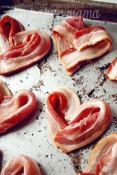 bacon in the shape of a heart on top of a sheet of tin foil next to an instagram page