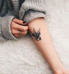 a woman's arm with a bird tattoo on the left side of her leg