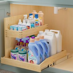 two wooden shelves holding cleaning products and detergents in a bathroom sink area, with one shelf open to show the contents