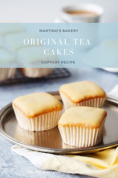 three cupcakes sitting on top of a metal plate next to a cup of coffee