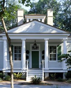 a white house with columns and green door