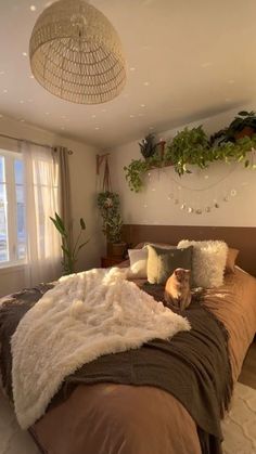 a bedroom with a large bed covered in blankets and pillows, plants on the wall