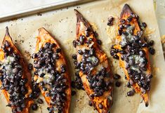 baked sweet potatoes with black beans and cheese on a baking sheet, ready to be eaten