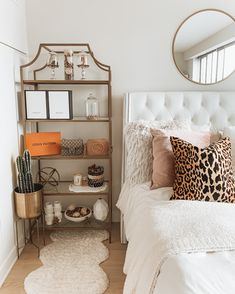 a bedroom with a bed, mirror and other items on the shelf in front of it