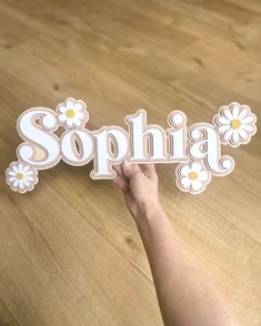 someone is holding up a sign that says sophiia with daisies on it