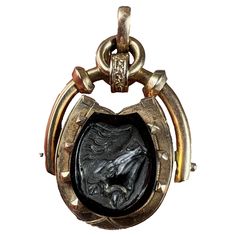 An 18 karat (18K) rose gold pendant locket with rotating horseshoe design set to one side with an onyx plaque, to the other with an onyx cameo of a horse's head. Opening to reveal a round photo locket to one side. Stamped with the owl mark for French import and 18 karat gold. Dimensions: 3.5 x 2.9 x 1.17 cm (not including jump ring) Weight: 12.47 grams (Chain not included) Horseshoe Design, Pendant Locket, Rose Gold Pendant, Photo Locket, Horse Head, Design Set, Jump Rings, 18k Rose Gold, Gold Pendant