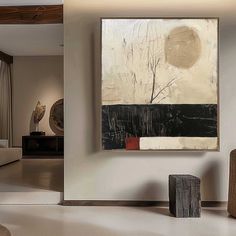 an abstract painting hangs on the wall in a living room with white walls and flooring