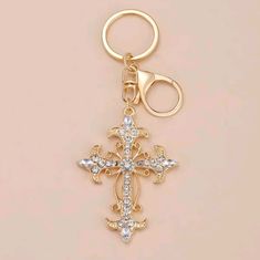 a gold cross keychain with a pair of scissors on the front and side