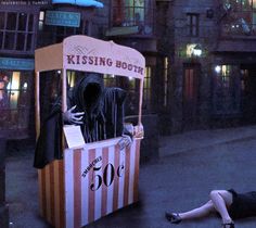 a woman laying on the ground in front of a kiosk with a ghost inside