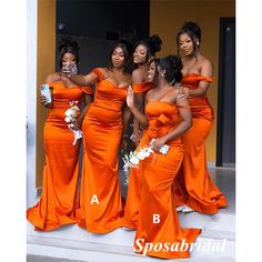 a group of women in orange dresses posing for the camera