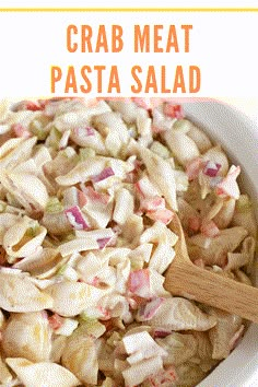 a white bowl filled with pasta salad next to a wooden spoon and text overlay that reads crab meat pasta