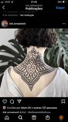 the back of a woman's neck with an intricate tattoo design on her neck