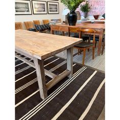 a dining room table with chairs and pictures on the wall