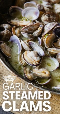 a pan filled with clams on top of a wooden table