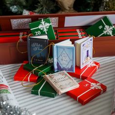 several books are sitting on top of each other with christmas wrapping around them and wrapped in twine