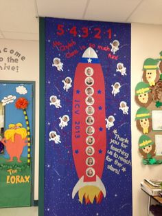 a bulletin board with an image of a rocket ship on it and other decorations around it