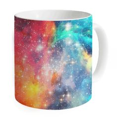 a colorful coffee mug with stars in the sky and clouds on it's side