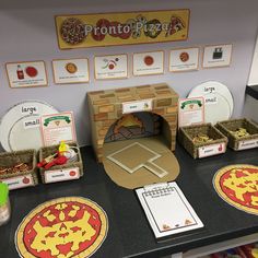 a table topped with lots of pizzas and paper plates on top of it's counter