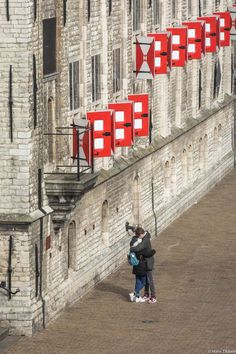 two people standing next to each other in front of a building with red signs on it