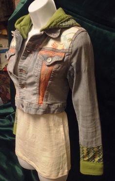 a mannequin wearing a jean jacket with an open collar and green linings