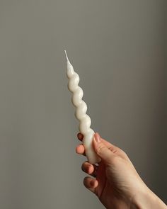 a person holding a candle in their hand with the light turned on and white candles sticking out