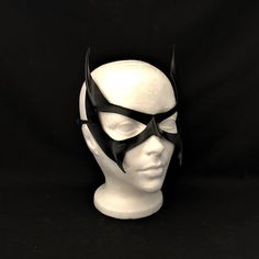 DESCRIPTIONSleek & Sexy... Meow! This seductive Catwoman mask is a best seller! Kick Batman's bat-butt in this lightweight black leather mask for your Catwoman Cosplay costume. Show Gotham City that the crafty cat is in charge. Or wear for Batgirl, Batman, or Wolverine from The X-Men! Great superhero Halloween Mask. Any color. Waterproofed leather, glossy or matte finish, & several choices to affix the mask (cord, elastic, ribbon, waterproof cord, stick, or no holes for adhesive). Measur Superhero Black Masks And Prosthetics For Halloween, Fitted Mask Costume Accessories For Cosplay, Fitted Black Masks For Costume Party, Black Full Face Masquerade Mask For Cosplay, Fitted Black Costume Mask, Fitted Black Mask Costume Accessories, Adjustable Black Masks For Costume Party, Black Eye Mask Costume Accessories For Cosplay, Fitted Black Eye Mask For Masquerade