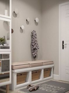 a white entryway with several baskets on the floor and a coat rack above it