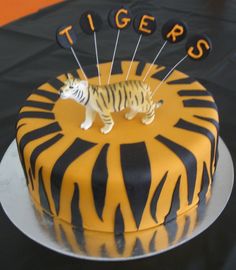 a tiger cake with pins stuck to it's head and the word tigers on top