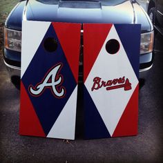 two atlanta braves cornhole game boards sitting in front of a car