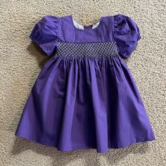 Adorable Smocked Dress. New, Never Worn. Came From Vendor Without Tags. Purple Fitted Dress With Smocked Bodice, Fitted Purple Dress With Smocked Bodice, Fitted Purple Dresses With Smocked Bodice, Cute Smocked Dress For Dress-up, Fitted Cotton Smocked Dress With Elastic Sleeves, Casual Smocked Dress With Smocked Back For Playtime, Purple Casual Smocked Dress, Short Sleeve Dresses With Smocked Back For Playtime, Purple Casual Smocked Dress With Smocked Back