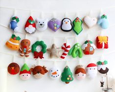 there are many felt christmas decorations hanging on the clothesline with pegs attached to it