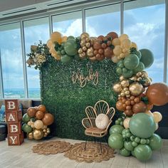 a backdrop made out of balloons and greenery for a baby's first birthday