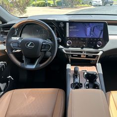 the interior of a car with tan leather seats and an electronic display in the center