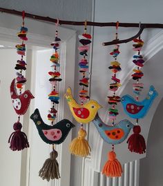 several colorful bird ornaments hanging from a door