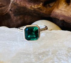 a green ring sitting on top of a rock