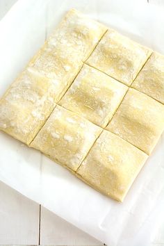 a square shaped pastry sitting on top of a piece of wax paper