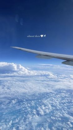 the wing of an airplane flying over clouds