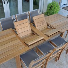 a wooden table with six chairs on top of it next to a patio and sliding glass doors