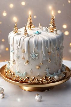 a white frosted christmas cake with gold decorations and lit candles on a platter