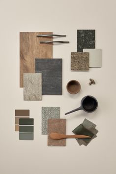 various materials are arranged on a white surface, including wood spoons and paint swatches