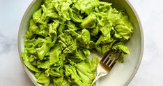 a bowl filled with lettuce and a fork