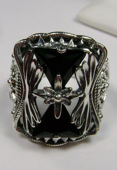 "Ring Description Made To Order This is a lovely Art Deco era reproduction ring in solid sterling silver. The gorgeous filigree ring is set with 2 trillion cut black CZs. The 2 black CZ's are 9mm x 9mm x 9mm in dimension. This filigree setting is a casting from an actual Antique ring; notice the amazing filigree band and setting... The ring sits 7/8th\" (22mm) NS on the finger. The quality of the silver and gemstones is simply breathtaking... a ring that will last for countless years to come... Victorian Silver Engraved Ring For Formal Occasions, Vintage Open Ring With Intricate Design, Ornate Filigree Ring With Stone Setting For Formal Occasions, Victorian Filigree Ring Stamped 925 For Gift, Silver Filigree Ring For Formal Occasion, Silver Filigree Ring With Stone Setting For Formal Occasions, Elegant Silver Engraved Ring With Stone Setting, Victorian Filigree Ring Stamped 925 As Gift, Ornate Filigree Ring With Stone Setting