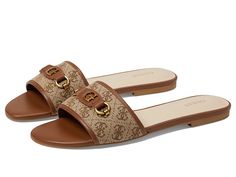 GUESS Hammi - Women's Sandals : Cognac : Display your love for modern aesthetics while adding an iconic touch to your look by opting for the GUESS Sandals which are versatile enough to be worn any day and everyday. Logo-printed fabric and faux leather upper with goldtone iconic logo accent. Synthetic lining and insole. Slip-on style for easy on and off. Open round toe. Durable and flexible synthetic rubber outsole. Imported. Designer Sandals With Leather Trim For Summer, Luxury Leather Trim Sandals For Summer, Luxury Sandals With Leather Trim For Summer, Flat Sandals With Logo For Summer, Summer Flat Sandals With Logo, Open Toe Sandals With Logo For Spring, Spring Open Toe Sandals With Logo, Spring Season Open Toe Sandals With Logo, Logo Slip-on Sandals For Summer