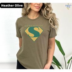 Unisex green SUPERMOM T-shirt. This will be the perfect gift for your mother for mother's day or any other occasion.  Visit our shop for alternate versions of this logo with different colors (blue, black/white, pink) https://www.etsy.com/shop/DressedInPrints FABRICATION 100% Airlume combed and ring-spun cotton, 32 single 4.2 oz. (Ash - 99% Airlume combed and ring-spun cotton, 1% poly) 𝐇𝐎𝐖 𝐓𝐎 𝐎𝐑𝐃𝐄𝐑 ----------------------------------------------------------------------------------------- Personalized Green Cotton Tops, Graphic Tee T-shirt As Gift In Green, Personalized Green Cotton T-shirt, Personalized Green Short Sleeve Tops, Green T-shirt With Letter Print For Mother's Day, Green Short Sleeve T-shirt For Mother's Day, Mother's Day Green Short Sleeve T-shirt, Mother's Day Green T-shirt With Letter Print, Custom Print Green Tops For Gifts