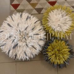 three pieces of fur sitting on top of a tile floor next to a rug and wall