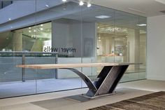 an office building with glass walls and a wooden table in front of the door that says neverwells