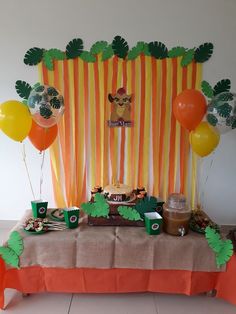 a table topped with lots of food and balloons